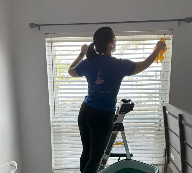 Keva's cleaner wiping window blinds in a Tampa office
